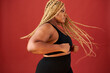 © Roman - side view on african american overweight woman in action, she is doing exercises or dancing alone, wearing black sportswear. long haired female, body positive