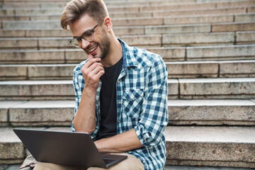 Young smiling man sitting on steps