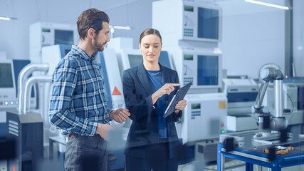 Aufkleber - Modern Factory: Female Project Manager and Male Engineer Standing, Talking, Using Digital Tablet for Programming and Monitoring Assembly Line. Industry 4.0 Facility with High-Tech CNC Machinery