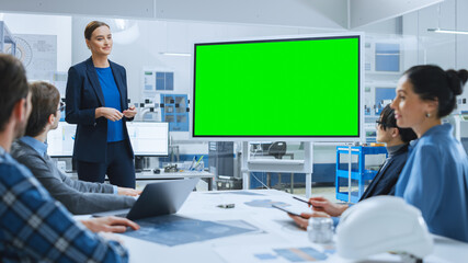 Poster - Modern Industrial Factory Meeting: Confident Female Engineer Uses Interactive Green Mock-up Screen Whiteboard, Makes Report to a Group of Engineers, Managers 