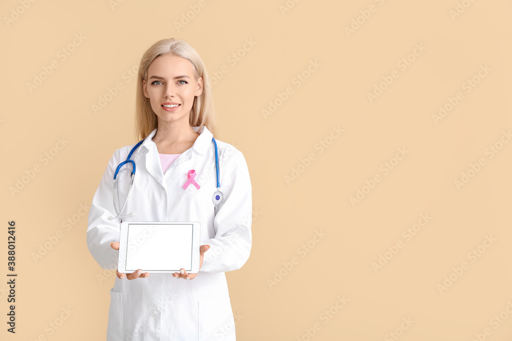 Doctor with pink ribbon and tablet computer on color background. Breast cancer awareness concept