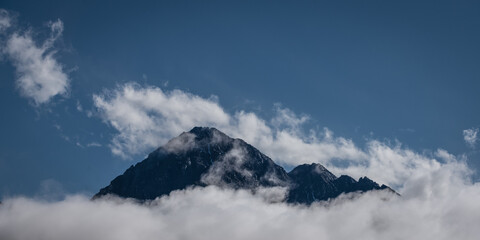 Wall Mural - peak of mount Thaneller in reutte austria with clouds at the bottom and blue sky