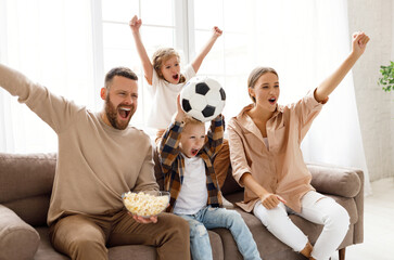 Wall Mural - Excited family watching football at home.