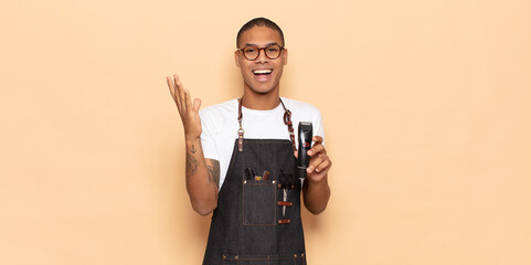 Wall Mural - young black man feeling happy, surprised and cheerful, smiling with positive attitude, realizing a solution or idea