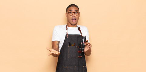 Wall Mural - young black man feeling extremely shocked and surprised, anxious and panicking, with a stressed and horrified look