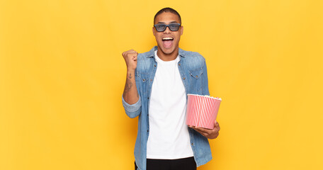 Canvas Print - young black man feeling shocked, excited and happy, laughing and celebrating success, saying wow!