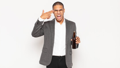 Wall Mural - young black man looking unhappy and stressed, suicide gesture making gun sign with hand, pointing to head