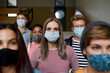 © Halfpoint - Front view of young students with face masks back at college or university, coronavirus concept.