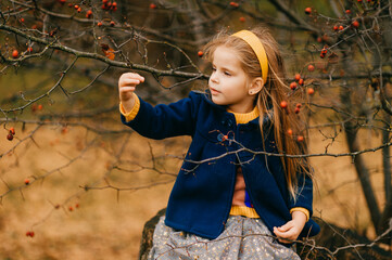 A young cute girl posing in autumn park