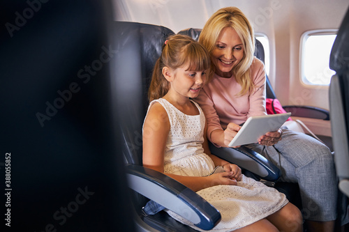 Mother showing her daughter something exciting on a tablet screen
