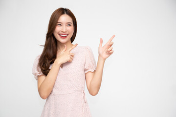 Young elegant beautiful Asian woman smiling and pointing to empty copy space isolated on white background