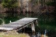 An old abandoned rickety dock juts out into a small pond in a forest near the small town of Mulmur, Ontario.