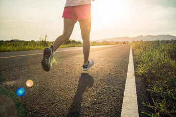 athlete woman runner running on a Countryside Road at Sunrise.Jogging workout and sport healthy lifestyle.Active,start up and healthy lifestyle concept.