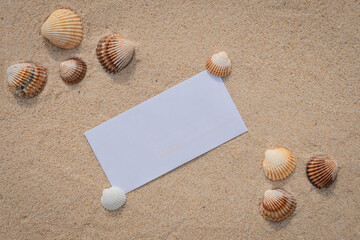 Arrière-plan grains de sable de mer, sable fin de plage avec enveloppe et coquillages. Emplacement pour texte sur papier.