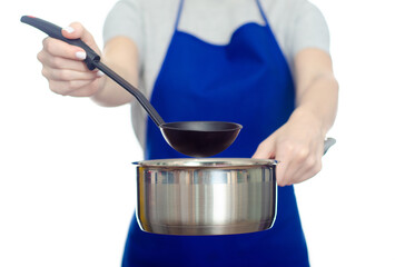 Wall Mural - Woman in apron holding stainless saucepan with mug in hand cooking on white background isolation