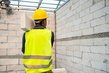Aufkleber - Masonry worker make concrete wall by cement block and plaster in the new house under construction.