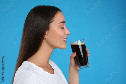 Beautiful woman with cold kvass on blue background. Traditional Russian summer drink