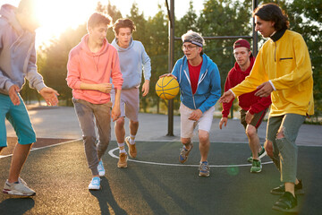 catch it. positive delighted teenager boys play basketball, want to win, every competitor wants to get the ball and score a goal