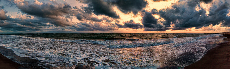 dramatic weather panorama over the sea threatening waves crashing at the shore with overcast golden 