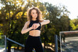 © dianagrytsku - Portrait of a young jogger looking at smart watch while standing outside