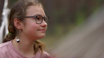portrait of cheerful girl smiling outside. teen girl swinging in hammock