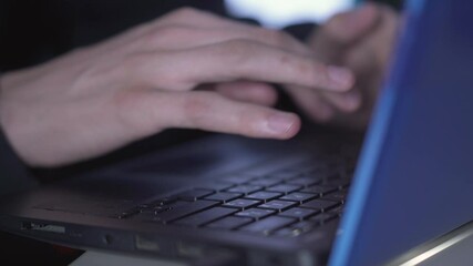 Wall Mural - male hands typing on laptop keyboard in darkness. unrecognizable young caucasian man coding computer