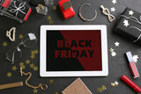 Fototapeta  - Flat lay composition with tablet, gifts and accessories on dark table. Black Friday sale