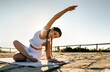 © Marco Govel/Westend61 - Young woman with eyes closed exercising on mat against clear sky at sunset