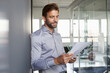 © Rainer Berg/Westend61 - Businessman reading document while leaning on wall in office