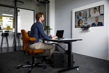 Businessman Attending Web Conference While Sitting In Office