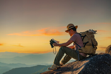 Wall Mural - men hike for tusks, happy to travel on the top of the mountain, sunset with a large backpack, lifest
