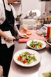 © Sergey Filimonov/Stocksy - Unrecognizable female cook preparing salad in kitchen
