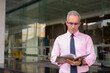 © Ranta Images - Handsome Persian businessman reading book outside modern building