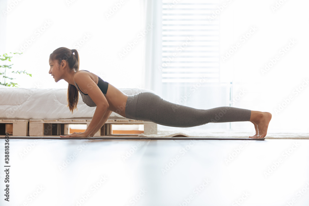 Attractive Asian woman practice yoga Plank pose to meditation in bedroom after wake up in the morning Feeling so comfortable and relax,Healthcare Concept - obrazy, fototapety, plakaty 