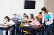 © JackF - Pretty little boys and girls with teacher drawing in classroom