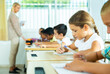 © JackF - Side view of group of primary school students and positive girl at a desk
