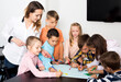 © JackF - Smiling team of elementary age children drawing on one sheet
