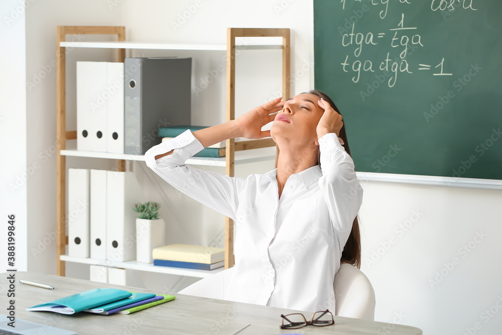 Stressed young female teacher in classroom
