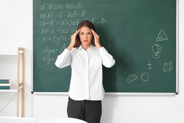Stressed young female teacher in classroom