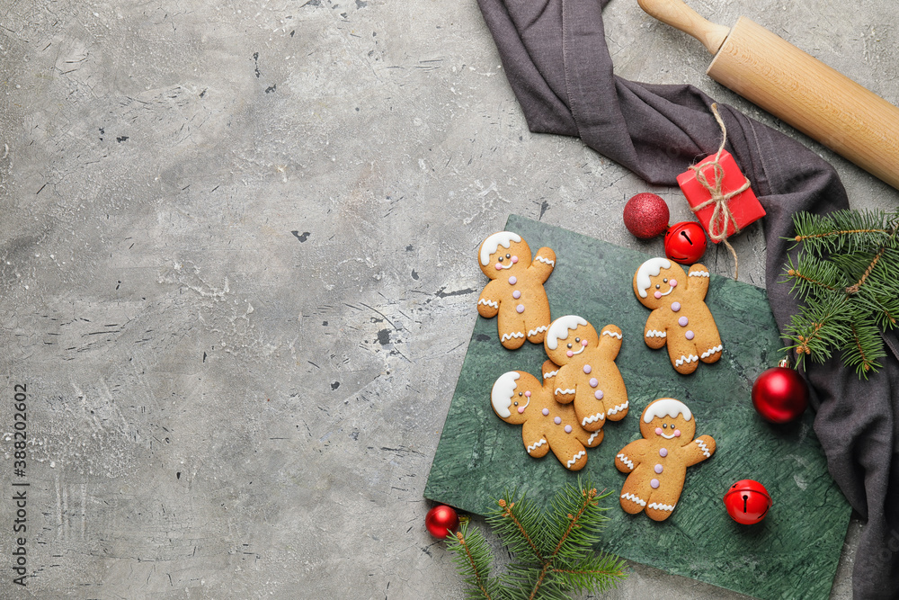 Tasty gingerbread cookies and Christmas decor on grey background