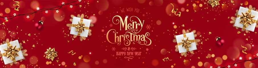 Wall Mural - gold merry christmas and new year text on red holiday background with gift boxes, fir branches, ribb