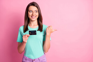 Wall Mural - photo portrait of woman holding credit card pointing thumb looking at pastel pink colored background
