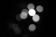 Blurry Light Circles Background In Black And White. Black Abstract Background In Blur.