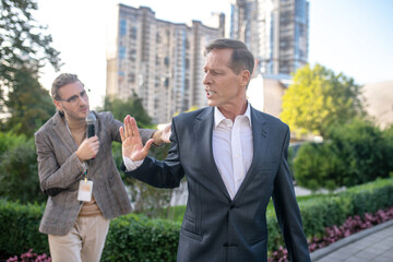 Mature man unwilling to give interview, walking away from male journalist