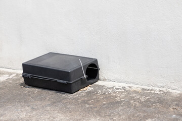 A black plastic rat trap on concrete floor. bait poison box for rat.