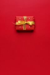 Wall Mural - Red Christmas gift on red background. Copy space, flat lay.