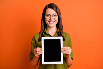 Wall Mural - photo portrait of smart female student showing tablet screen copyspace smiling isolated on vivid ora