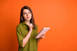 © deagreez - Photo portrait of thoughtful dreamy brunette girl writing with pen isolated on vivid orange color background