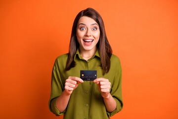 Sticker - Photo of funky shocked girl hold plastic card look camera open mouth wear green shirt isolated orange color background