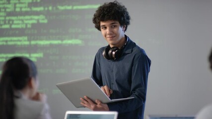 medium closeup of cheerful mixed race student with laptop in hands making speech on computer program